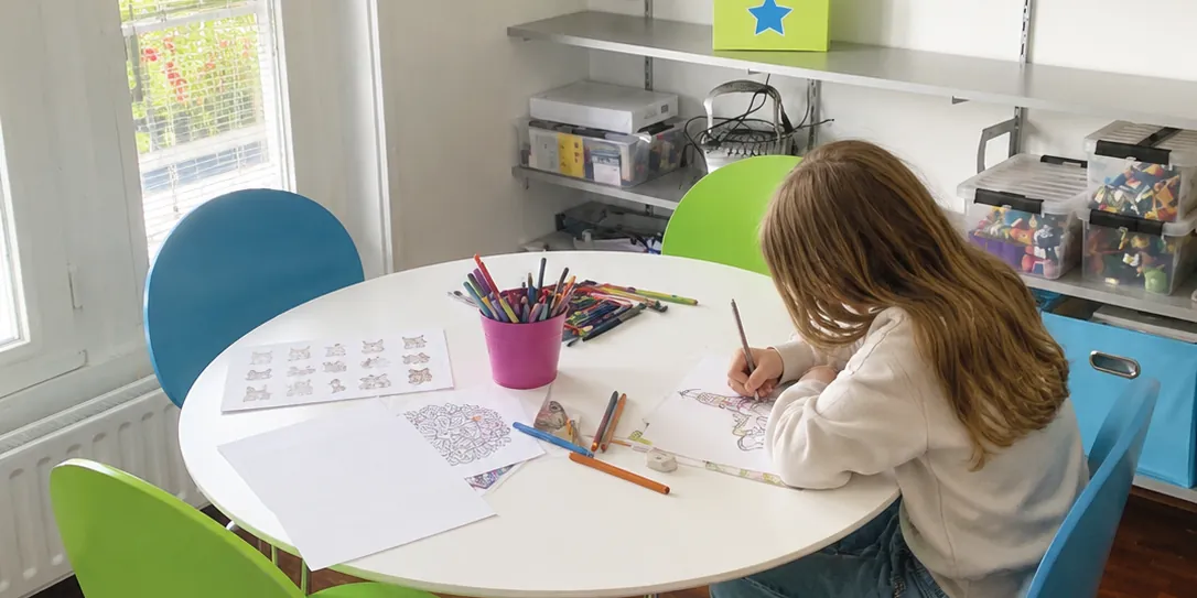 Kind is creatief bezig aan de tafel in de praktijkruimte